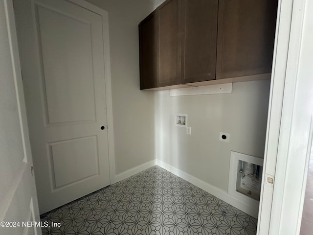 laundry area featuring electric dryer hookup, hookup for a washing machine, light tile patterned floors, and cabinets