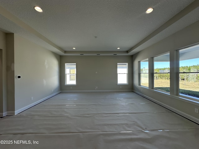 unfurnished room with recessed lighting, a textured ceiling, and baseboards