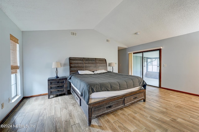 bedroom featuring a textured ceiling, lofted ceiling, access to outside, and light hardwood / wood-style floors