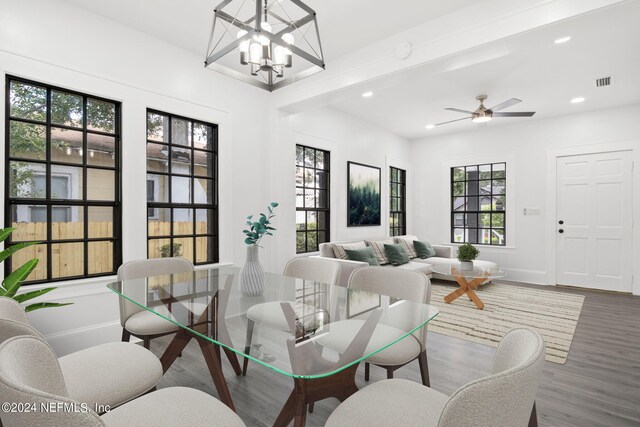 interior space featuring beam ceiling, ceiling fan with notable chandelier, and hardwood / wood-style flooring