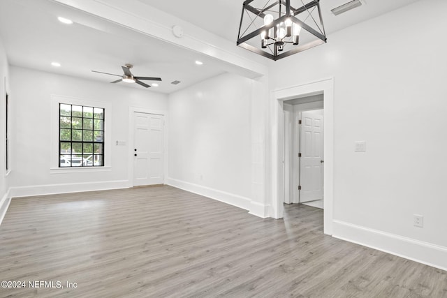 interior space featuring ceiling fan with notable chandelier and hardwood / wood-style floors