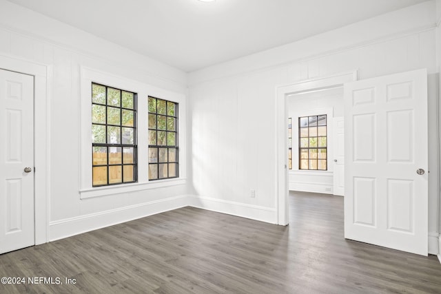 unfurnished room with dark wood-type flooring