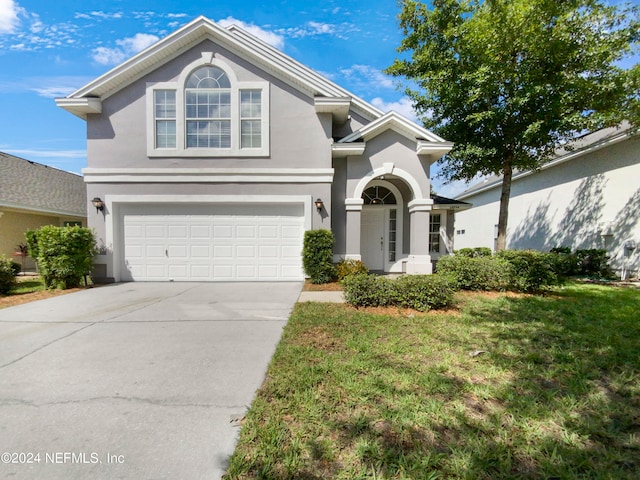 view of property featuring a front yard and a garage