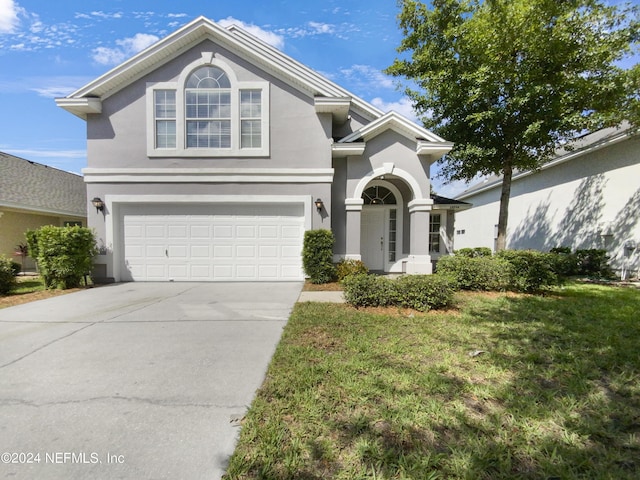 front facade with a garage and a front yard