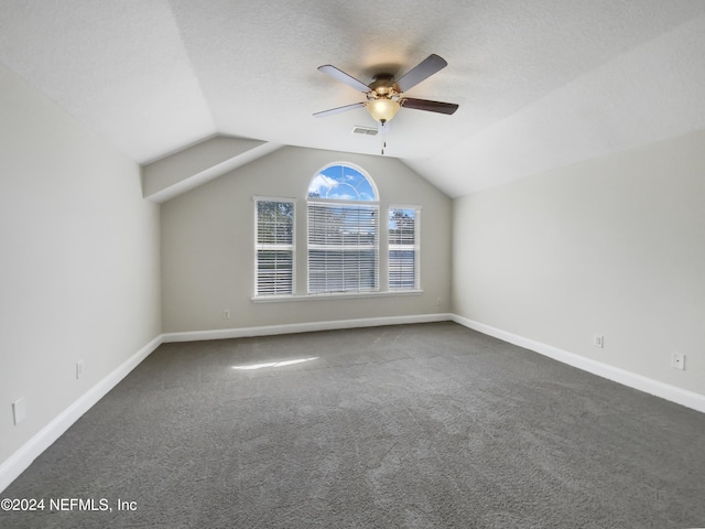 bonus room with dark carpet, vaulted ceiling, ceiling fan, and a textured ceiling