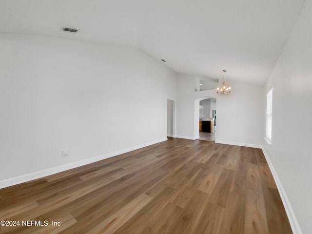 unfurnished living room featuring an inviting chandelier, hardwood / wood-style floors, and lofted ceiling