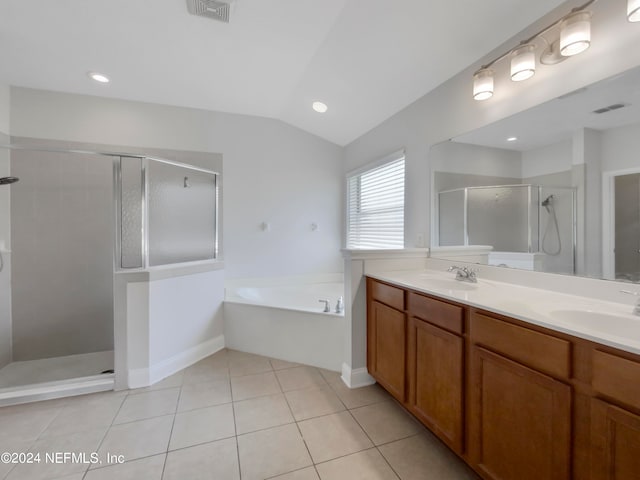 bathroom with double sink vanity, vaulted ceiling, plus walk in shower, and tile patterned flooring