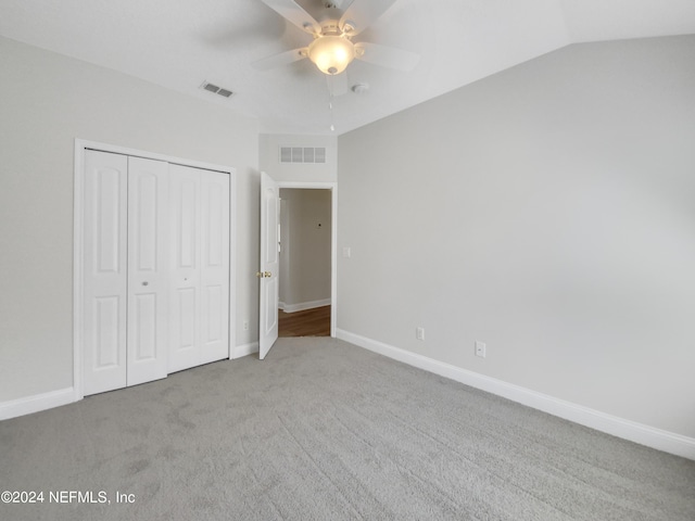 unfurnished bedroom featuring ceiling fan, light carpet, a closet, and lofted ceiling