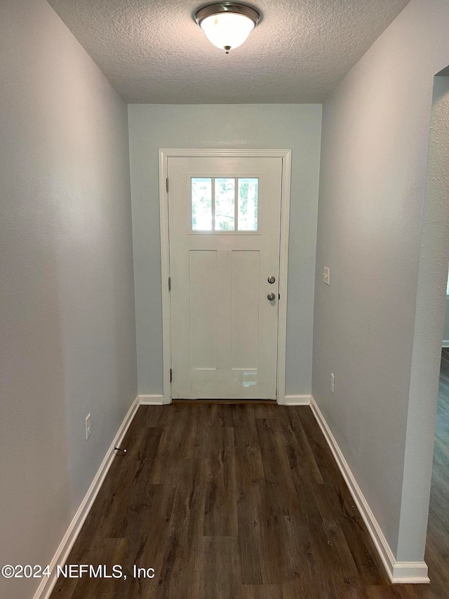 doorway to outside featuring a textured ceiling and hardwood / wood-style flooring