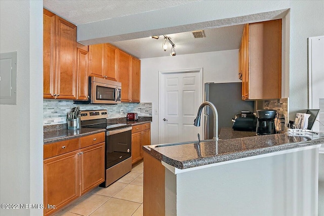 kitchen featuring appliances with stainless steel finishes, backsplash, kitchen peninsula, and electric panel