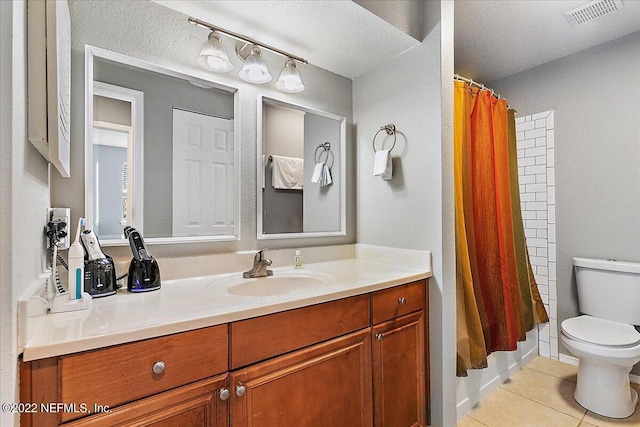 bathroom featuring vanity, a textured ceiling, toilet, and tile patterned flooring