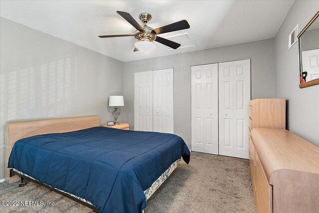 bedroom featuring two closets, ceiling fan, and carpet floors