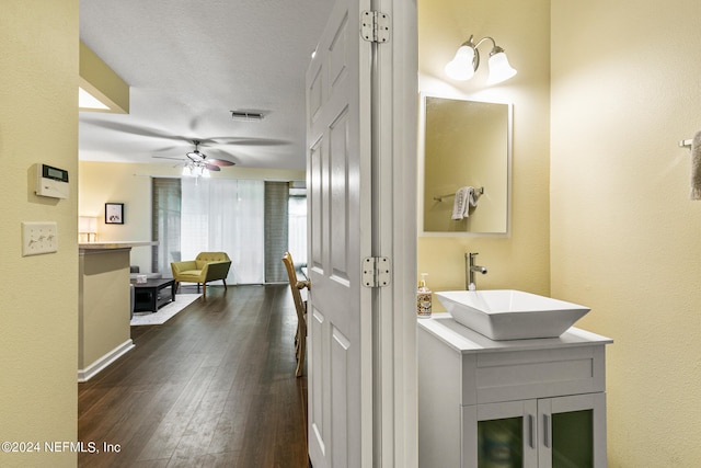 bathroom with hardwood / wood-style flooring, a textured ceiling, vanity, and ceiling fan