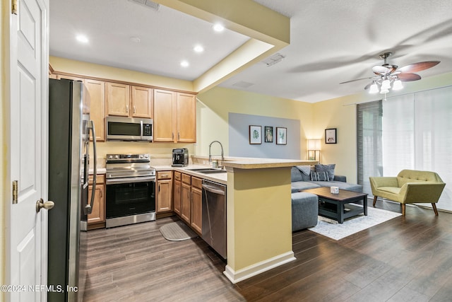 kitchen featuring sink, appliances with stainless steel finishes, dark hardwood / wood-style floors, ceiling fan, and kitchen peninsula