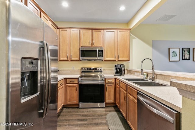 kitchen featuring sink, stainless steel appliances, kitchen peninsula, and dark wood-type flooring