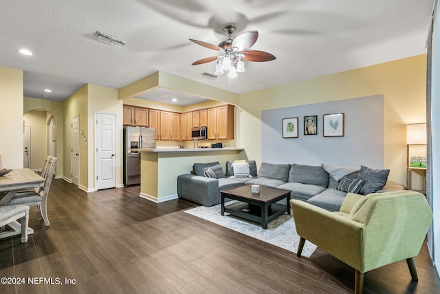 living room featuring hardwood / wood-style flooring, a textured ceiling, and ceiling fan