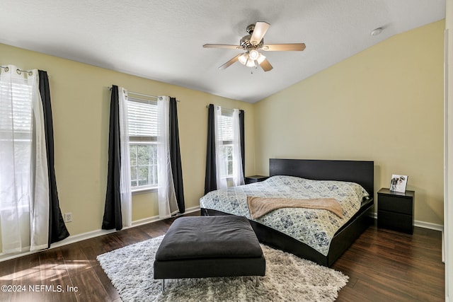 bedroom featuring ceiling fan, dark hardwood / wood-style floors, a textured ceiling, and lofted ceiling