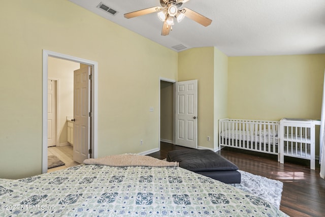 bedroom with hardwood / wood-style flooring, connected bathroom, lofted ceiling, and ceiling fan