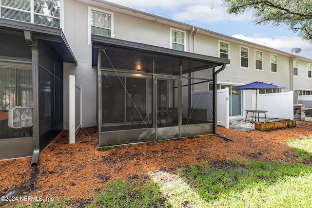 rear view of property featuring a sunroom