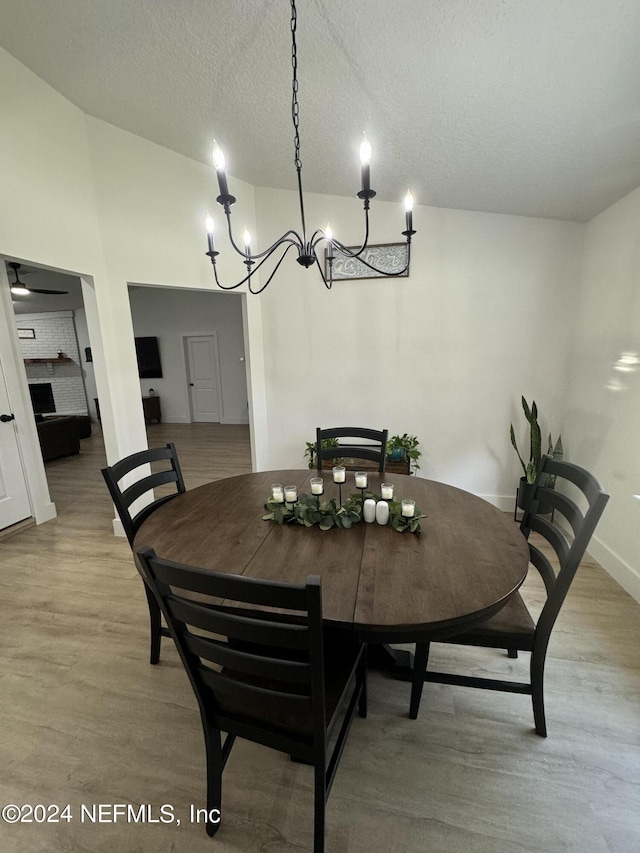 dining space with light wood-style flooring, baseboards, and a textured ceiling