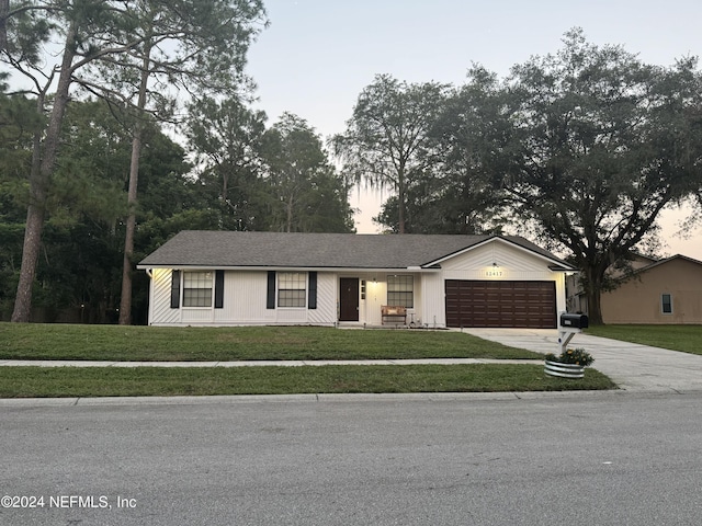 ranch-style house with a front yard, driveway, and an attached garage