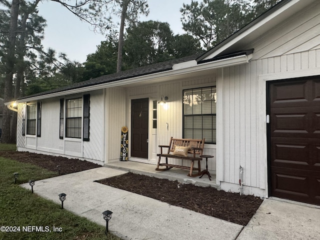 property entrance featuring a porch and a garage