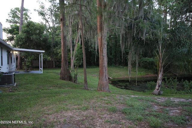 view of yard with a patio, fence, and central air condition unit