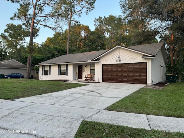 ranch-style home with a garage and a front lawn