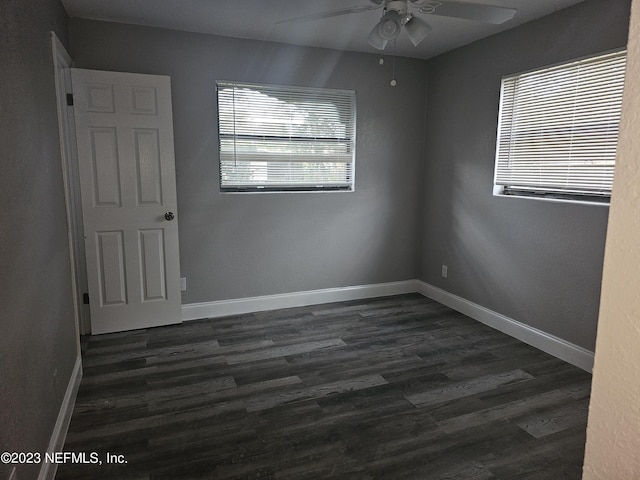 unfurnished room featuring a ceiling fan, baseboards, and dark wood-type flooring