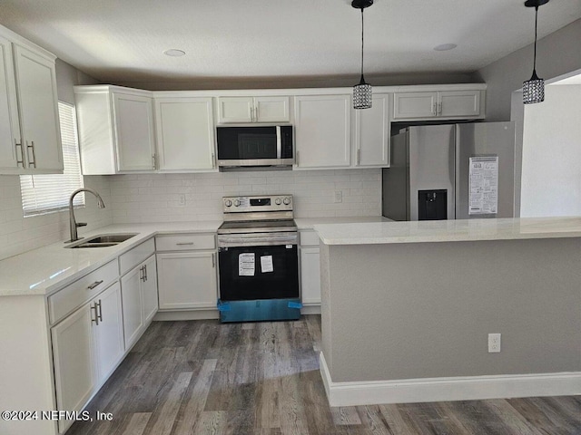 kitchen featuring a sink, white cabinets, light countertops, appliances with stainless steel finishes, and hanging light fixtures