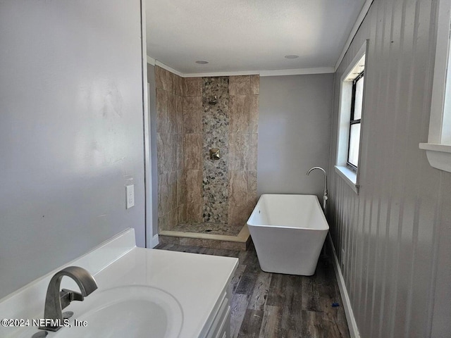 full bath with tiled shower, a soaking tub, ornamental molding, wood finished floors, and vanity