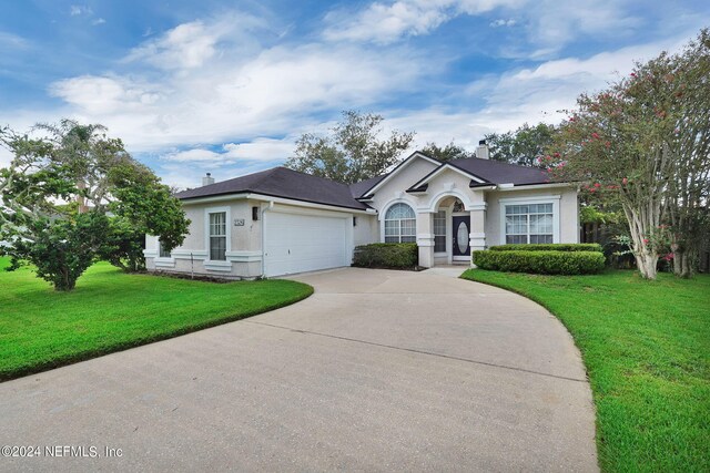 ranch-style house with a front yard and a garage