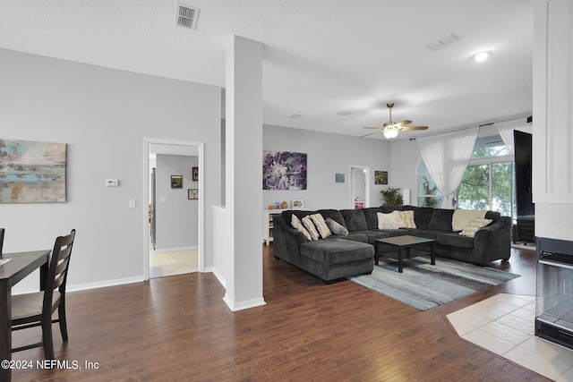 living room with ceiling fan, hardwood / wood-style flooring, and a textured ceiling