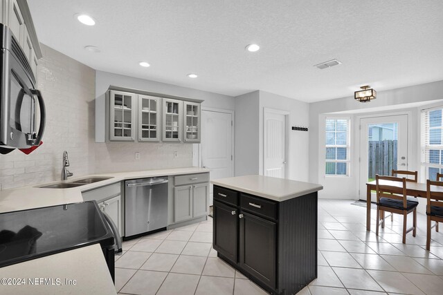 kitchen featuring appliances with stainless steel finishes, sink, tasteful backsplash, and light tile patterned floors