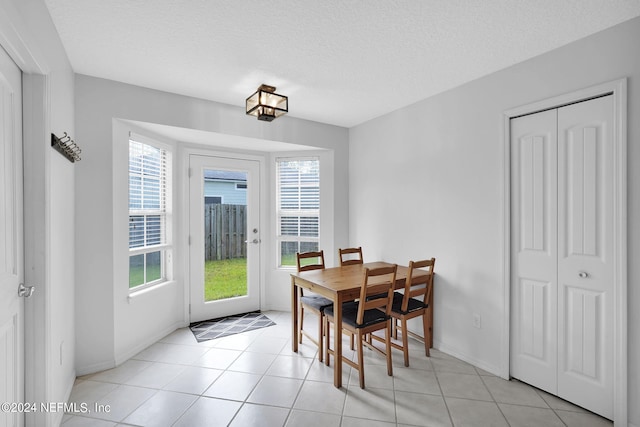 tiled dining area featuring a textured ceiling