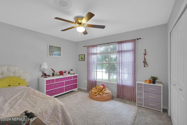 bedroom featuring ceiling fan, a closet, and carpet