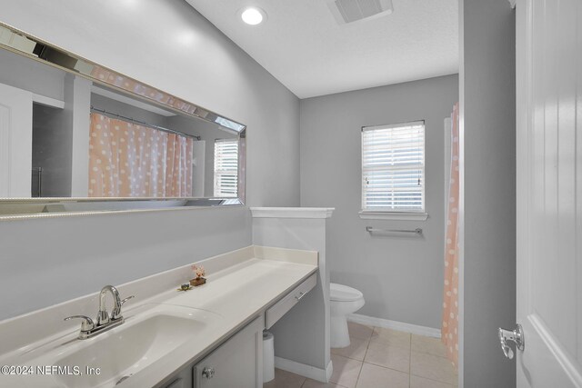 bathroom featuring tile patterned floors, vanity, and toilet