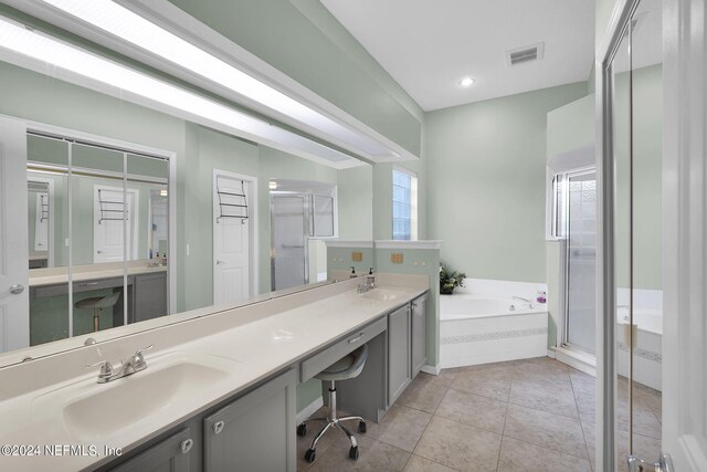 bathroom featuring tile patterned floors, double vanity, and separate shower and tub