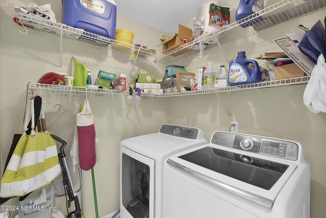 clothes washing area with a textured ceiling and washer and clothes dryer