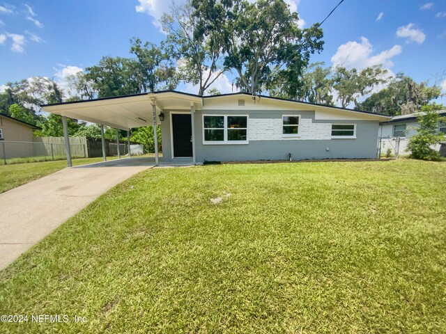 ranch-style house featuring a carport and a front lawn