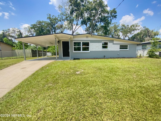 view of front of house with a carport, a front lawn, concrete driveway, and fence