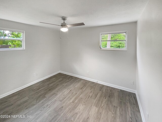 unfurnished room with ceiling fan, wood-type flooring, and a healthy amount of sunlight