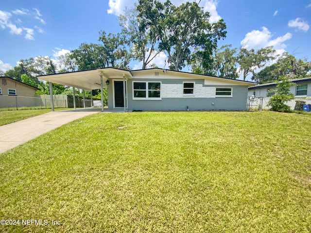 view of front of property featuring a carport, driveway, a front lawn, and fence