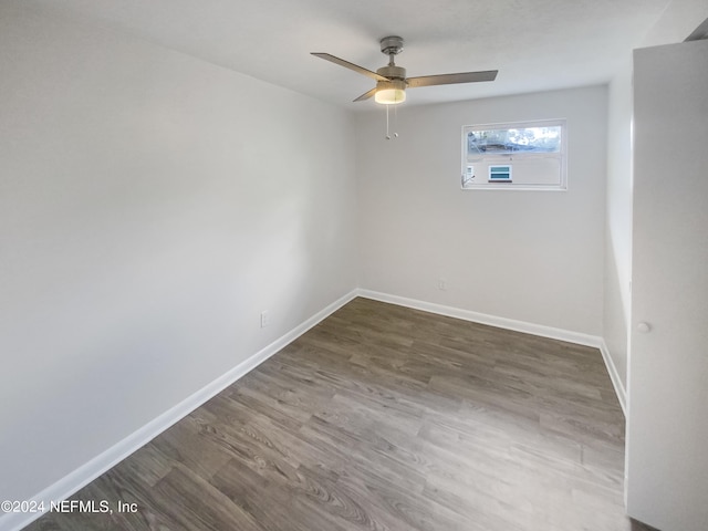 spare room featuring ceiling fan, baseboards, and wood finished floors