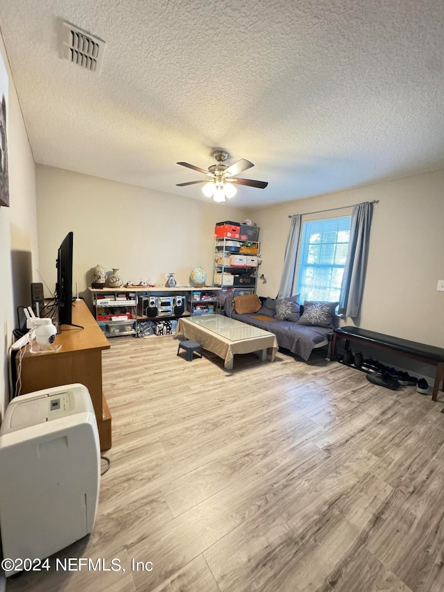 home office with a textured ceiling, ceiling fan, and hardwood / wood-style floors