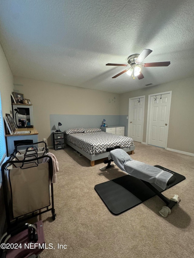 bedroom featuring a textured ceiling, ceiling fan, and carpet