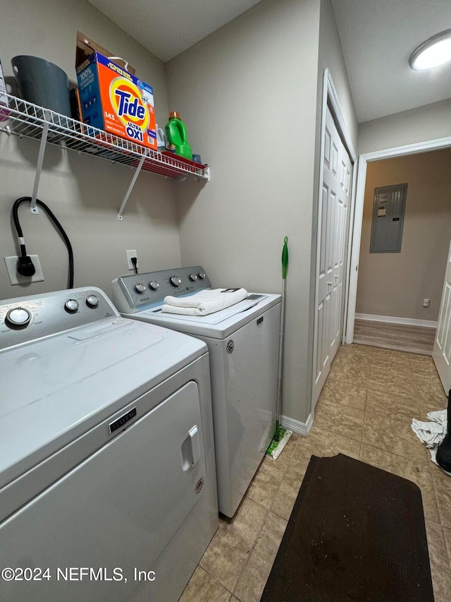 laundry area featuring electric panel, separate washer and dryer, and light tile patterned floors