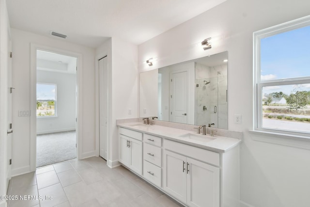 bathroom with tile patterned floors, vanity, and a shower with shower door