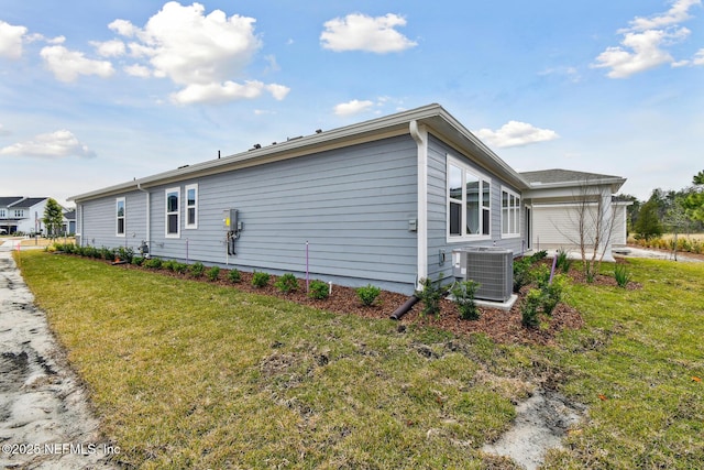 view of side of home with central AC and a lawn