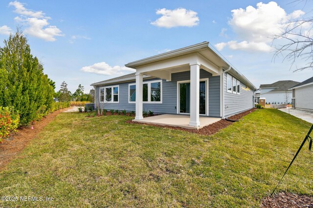 rear view of house with a yard and a patio area